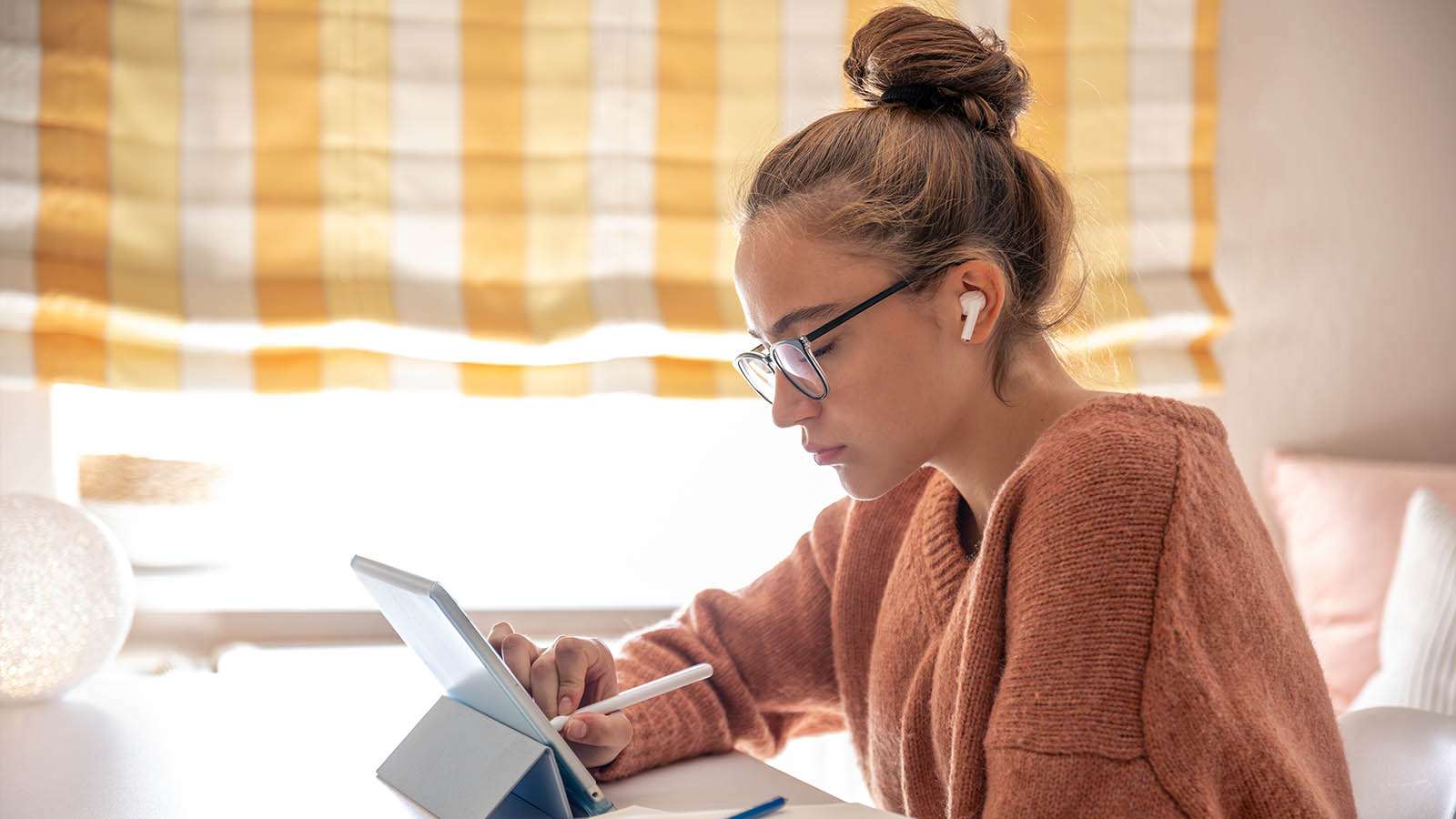 iPad til studie på skrivebord med noter, tastatur og bøger